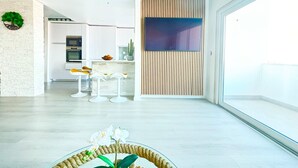 Un interior moderno con cocina, comedor y un ventanal grande.