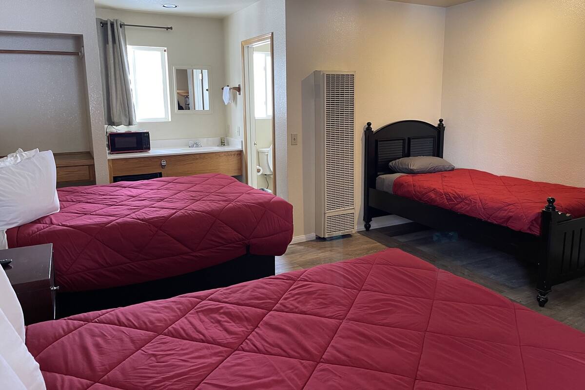 Une chambre d’hôtel avec deux lits, une salle de bain et une kitchenette.