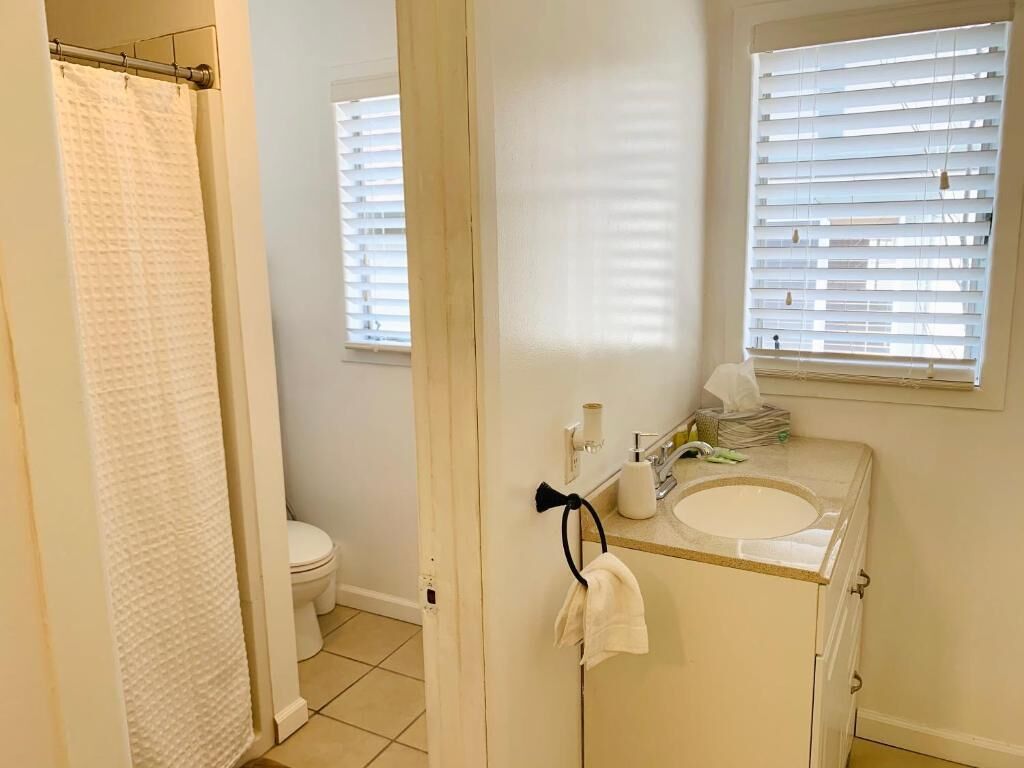 A bathroom with a toilet, sink, and towel rack.