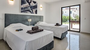 A hotel room with two beds, a large abstract painting, and a view of the outside.