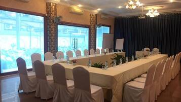 A conference room with a long table, white chairs, and a large window with a view.