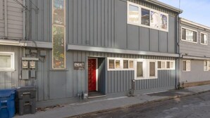 Un bâtiment à deux étages avec une porte rouge, un petit porche et une enseigne sur laquelle on peut lire « O’Neal ».