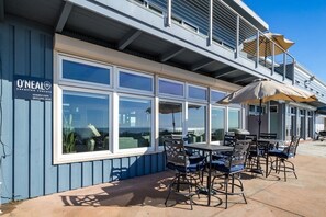 A seaside restaurant with outdoor seating and large windows overlooking the ocean. - Beachfront Rio Del Mar Home - 5 bedrooms! (Aptos)