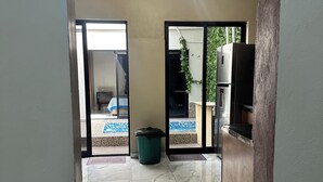 A hallway with a modern light fixture, a trash bin, and a refrigerator. - Casa a tan Solo 5 Minutos de la Plaza Principal! Ideal Para Familia y Amigos (Tequila)