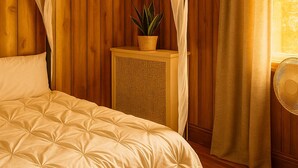 A bedroom with a four-poster bed, wooden paneling, a small side table with a plant, and a window with curtains. - Family-Friendly 4BR 10min MetLife & American Dream Mall• 20min NYC •Free Parking (North Bergen)