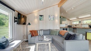 A modern living room with a grey sectional sofa, a small table with candles, and a bench.
