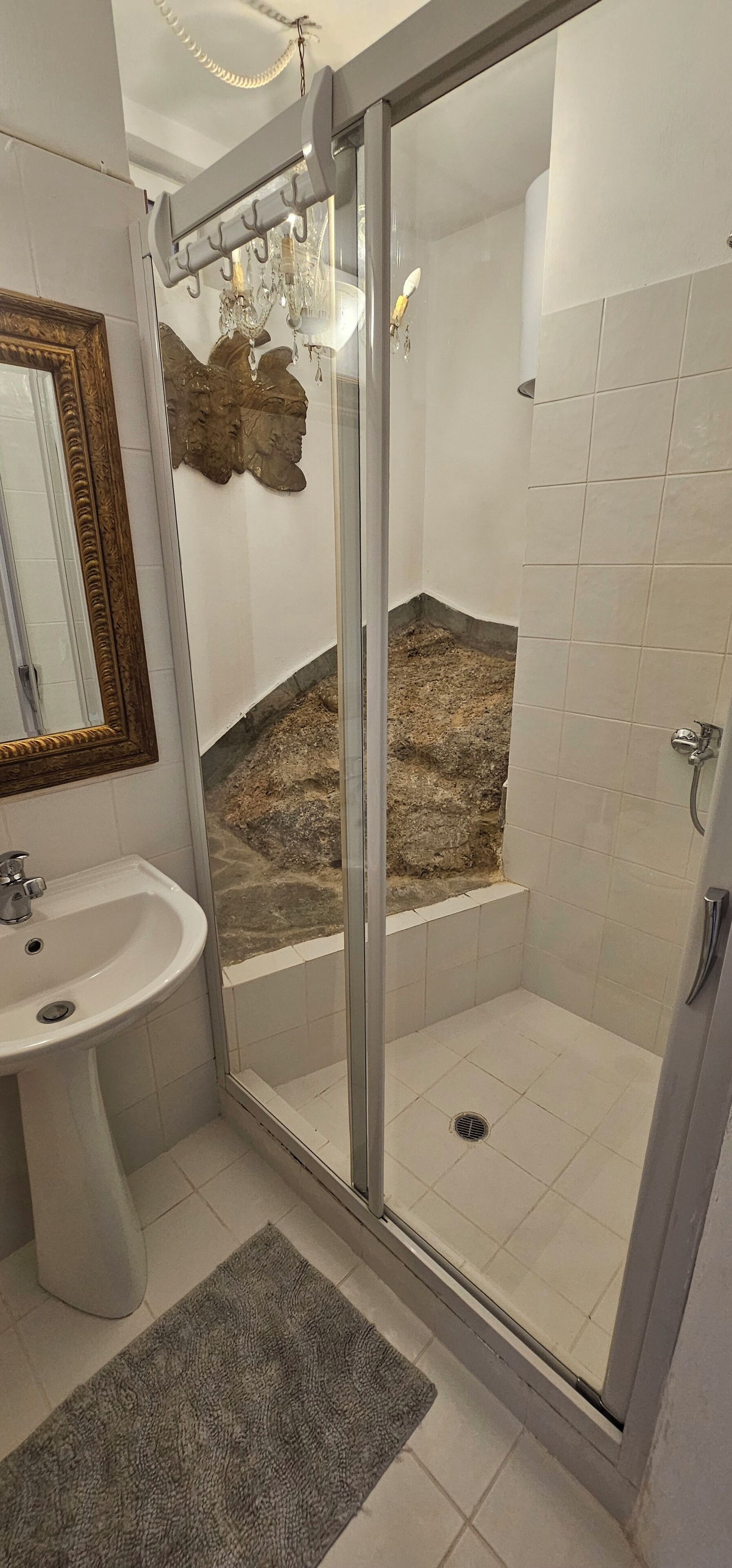 Une salle de bain avec une douche à parois de verre, un lavabo et un miroir.
