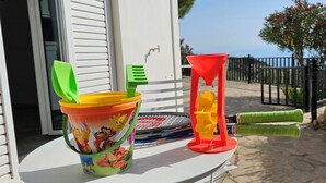 A table with a colorful bucket, a green and yellow toothbrush, and a red funnel. - Sea-view house with 360° rooftop in an olive grove — 2 hrs from Athens (Akrata)