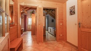 A wooden interior with a bench, a door, and a hallway leading to another room. - Ferienwohnung »stadtblick« 50m², 2 Personen, Nichtraucher, Balkon, W-lan (Traunstein)