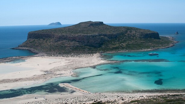 An aerial view of a coastal area with a prominent rocky island, clear turquoise waters, and a sandy beach. - 2 Annexed Apartments -private Place to Swim-large Terrace- Unlimited View (Platanias)