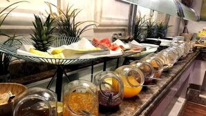 A buffet setup with various food items and condiments. - Karim Hotel Al Olya (Al Khobar)