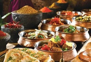 A variety of dishes and spices displayed in metal bowls and a mortar. - Karim Hotel Al Olya (Al Khobar)