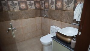 A bathroom with a toilet, sink, and shower. - Hotel Lyf Suites - bahadurgarh (Bahadurgarh)