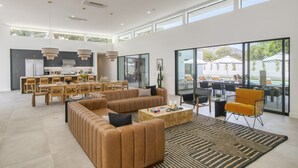 A spacious living area with a large sofa, coffee table, and dining area with chairs and a table. - The Reserve at Polo Villas #16 | Sleeps 18 • Grand La Quinta Villa • Pool + Spa (La Quinta)