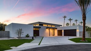 Ein modernes Haus mit Garage, Auffahrt und gepflegtem Rasen.