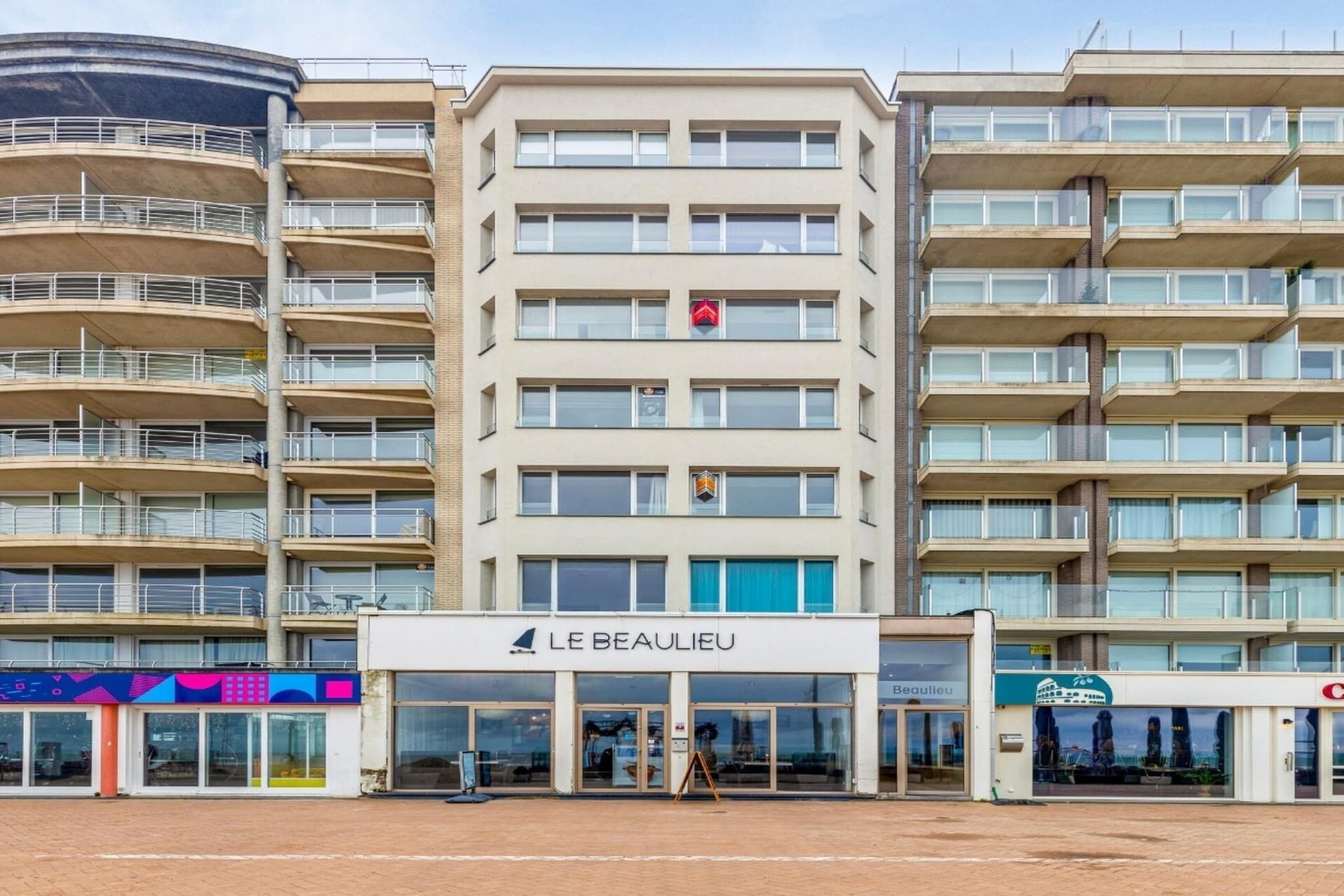 A multi-story hotel with a central entrance and balconies.