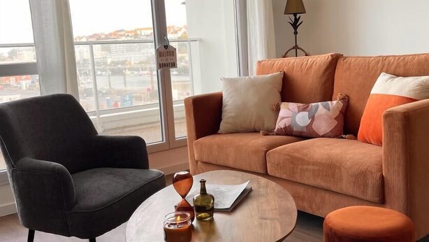 Un salon moderne avec un canapé, un fauteuil et une table basse.