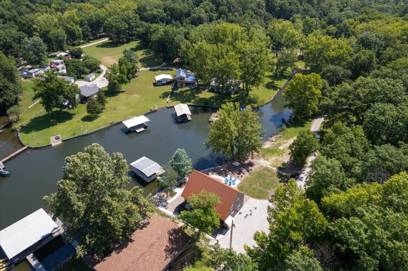 Ett flygbildsbild av ett bostadsområde med en flod, hus och en brygga.