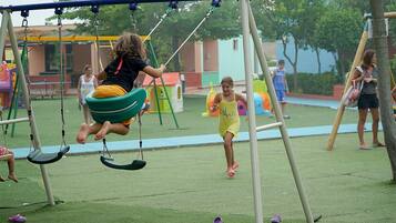 Children can play on the swing set and slide in the grassy area.