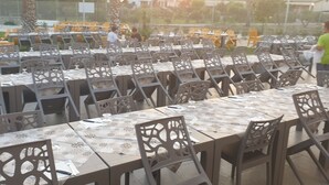 An outdoor dining area with multiple tables and chairs, arranged in rows. - Villaggio le Palatine (Bernalda)