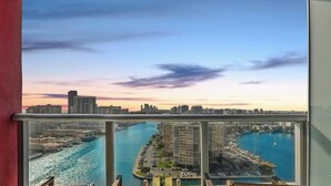 A high-rise building with a view of a marina and city skyline at sunset. - Spectacular Apt: Amazing Pools + Gym (Hallandale Beach)