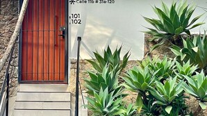 A wooden door with a metal gate, a stone wall, and a sign indicating Calle 11b # 31a-120.