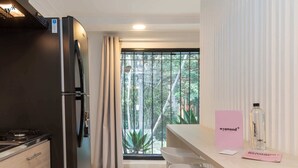 A modern kitchen with a refrigerator, stove, and bar area with stools.