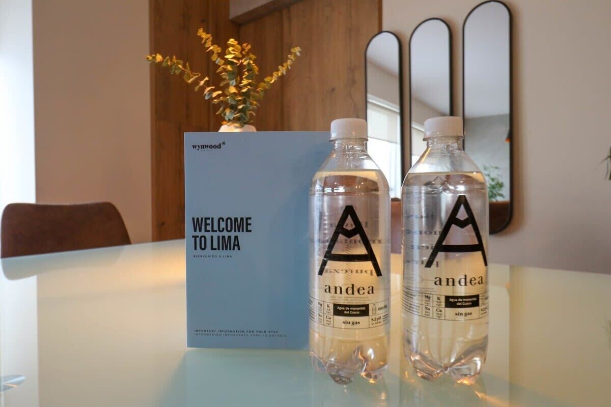 Een welkomstbord en twee waterflessen met 'andea'-logo op een tafel.