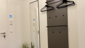 A bathroom with a white door, a mirror, a black towel rack, and two potted plants. - Dahmer Dünen - Ostseezauber! (Dahme)