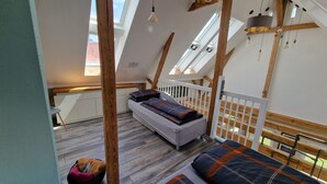 Dormitorio tipo loft con cama, un banco y vistas al exterior.