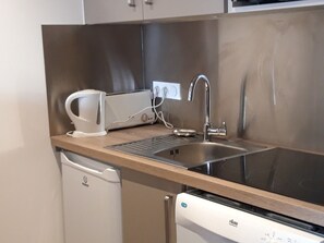 Uma cozinha moderna com pia de aço inoxidável, torradeira e lava-louças.