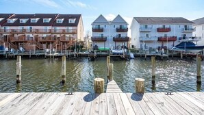 A waterfront property with multiple buildings, docks, and a wooden pier. - Waterfront Ocean Villa! (Ocean City)