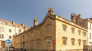 A historic building with a stone facade, multiple windows, and a prominent chimney. - St Catherine's Hospital - Superior Apartment (Bath and North East Somerset)