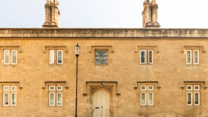 A historic building with a central entrance, multiple windows, and a plaque. - Split-Level Deluxe Suite · Sleeps 4 in Bath (Bath and North East Somerset)