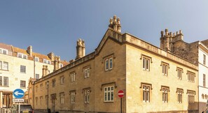 A historic building with a stone facade, multiple windows, and a prominent chimney. - St Catherine's Hospital - Superior Apartment (Bath and North East Somerset)