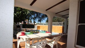 An outdoor patio with a table and chairs, a pool, and a view of trees and buildings. - Cozy Beach Home: Free WiFi, Optional AC, Pet-Friendly, Dog Beach Nearby (Deltebre)