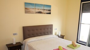 Un dormitorio con una cama grande, una mesita de noche y una ventana con persianas.