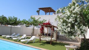 A poolside area with lounge chairs, a pergola with flowers, and a stone wall. - Family-Friendly Home with Pool, Near Beach, Pet Friendly, Free WiFi, Opt. AC (Deltebre)