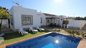 Uma casa moderna com piscina, área de estar externa e um pátio.