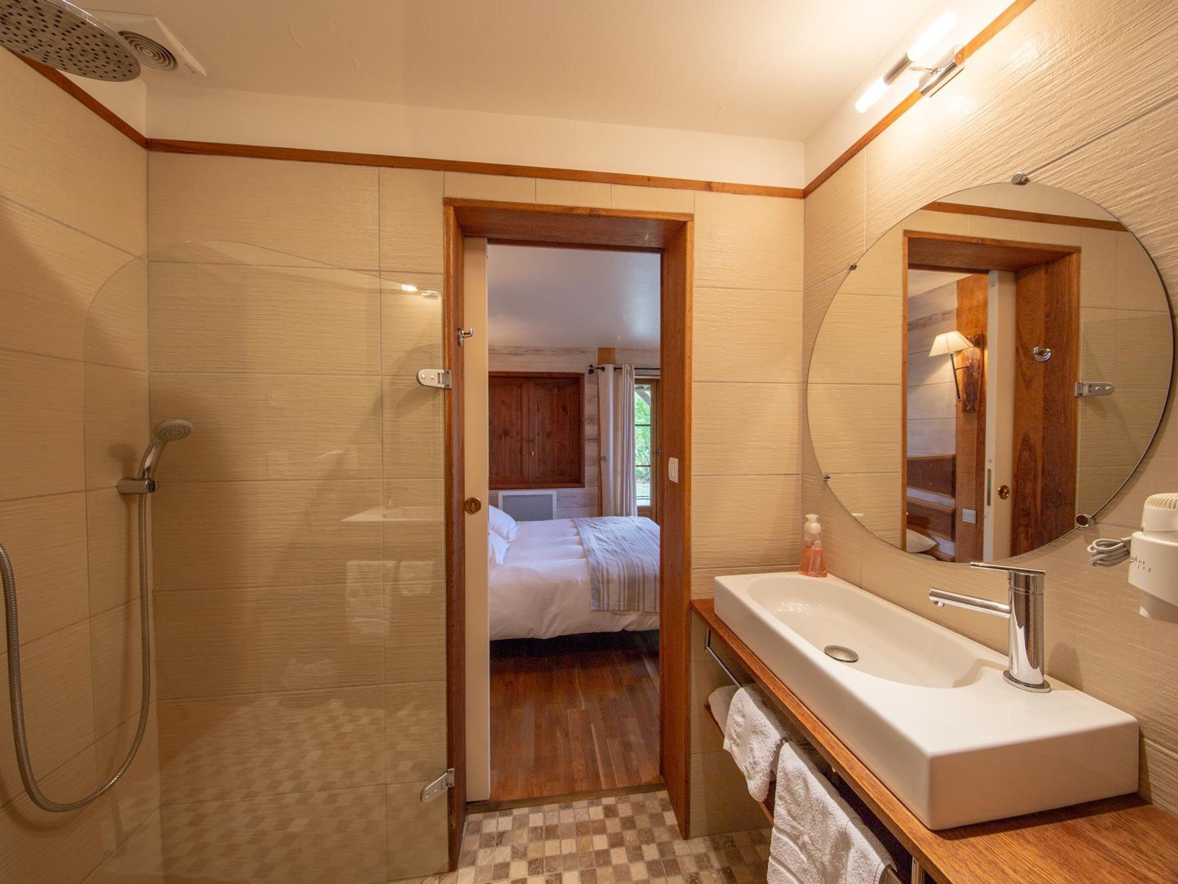 Une salle de bain avec une douche, un lavabo et un miroir.