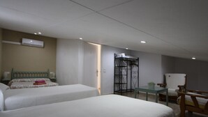 A hotel room with two beds, a chair, a table, and a wardrobe. - Cozy Beachside Home: Private Pool, Pet-Friendly, WiFi, A/C Option, Near Dog Beach (Deltebre)