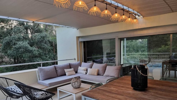 A modern outdoor living area with a wooden table, chairs, and a sofa. - Maison Contemporaine Avec Piscine à Mi-chemin Entre la Plage de Sa Tuna et Begur (Begur)