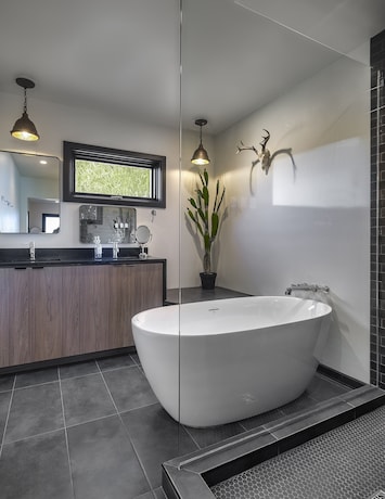 Step into the master bathroom at Tu'nlii House, where modern Southwest charm meets luxury. Indulge in a space thoughtfully designed with upscale amenities, creating a perfect blend of style and comfort for your rejuvenating retreat.