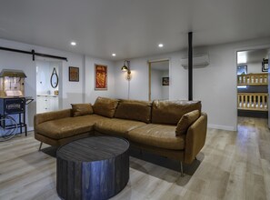 Relax in this stylish living space with a large L-shaped sofa, vintage popcorn machine, and framed artwork.