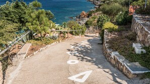 Eine Küstenstraße mit einer Steinmauer auf der rechten Seite und Blick aufs Meer.
