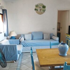Une pièce comprenant un ensemble de canapés, une table en bois, un vase et un élément décoratif mural.