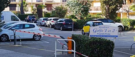 A gated parking area with a sign indicating 'Residence Golfé 1 et 2' and 'Propriété Privée'.