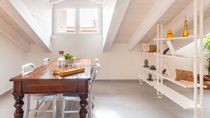 Ein Essbereich mit einem Holztisch, Stühlen und einer weißen Regaleinheit mit Dekoration.