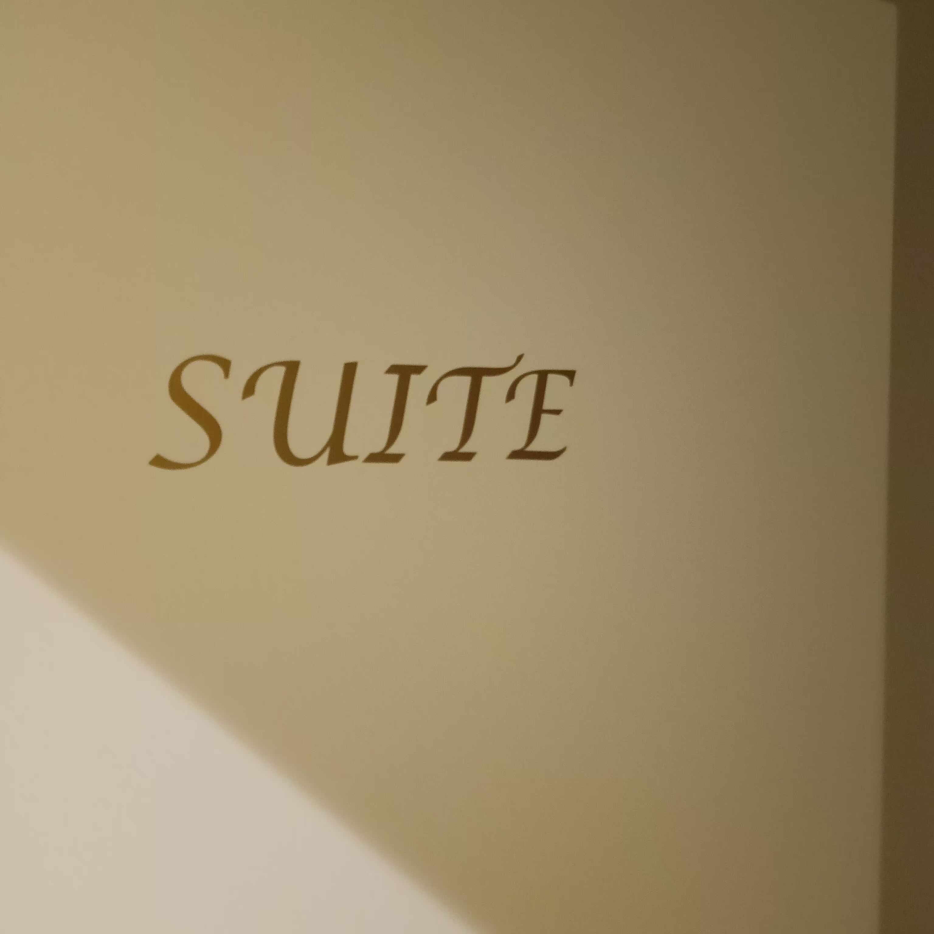 Une enseigne portant le mot « SUITE » écrit en caractères avec empattement.