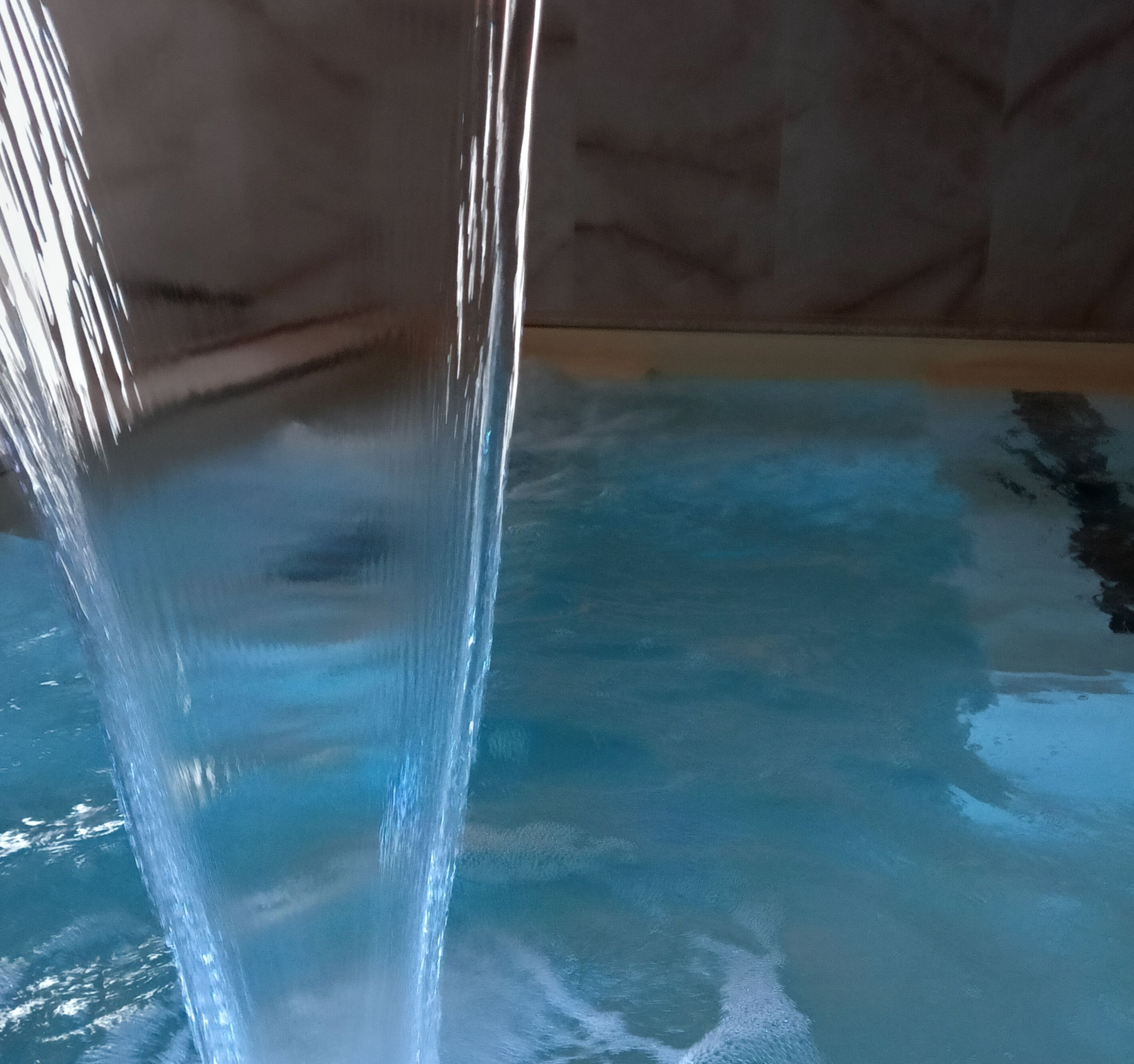 Una visuale chiara di un elemento acquatico con un corso d'acqua che sfocia in una vasca.